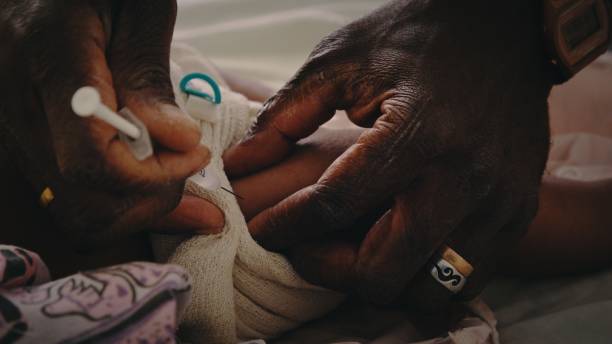 słodkie małe dziecko z czarnego pacyfiku, które zaszczepione jest zaszczepione podczas badania lekarskiego przez pielęgniarkę w szpitalu na odległej tropikalnej odosobnionej wyspie - south africa zdjęcia i obrazy z banku zdjęć