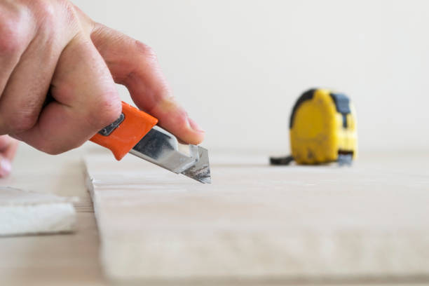 Cutting a sheet of drywall with a knife. stock photo