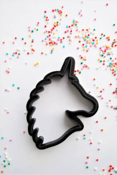 cutting for cookies in the shape of a unicorn stock photo