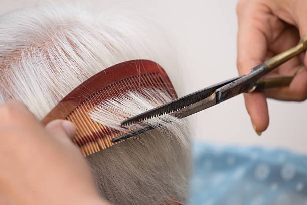 cutting senior woman's gray hair Hair stylist cutting senior woman's gray hair cutting hair stock pictures, royalty-free photos & images