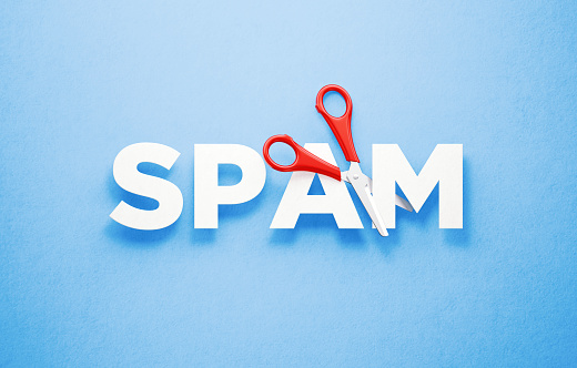 Red scissors cutting the word spam over blue background. Horizontal composition with copy space. Cutting spam concept.