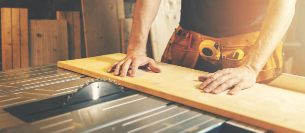 cutting wooden board on a table saw. woodworking and carpentry. furniture manufacturing stock photo