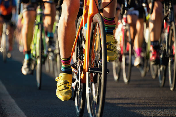 ciclismo de competición, atletas de ciclista montando una carrera - peloton fotografías e imágenes de stock