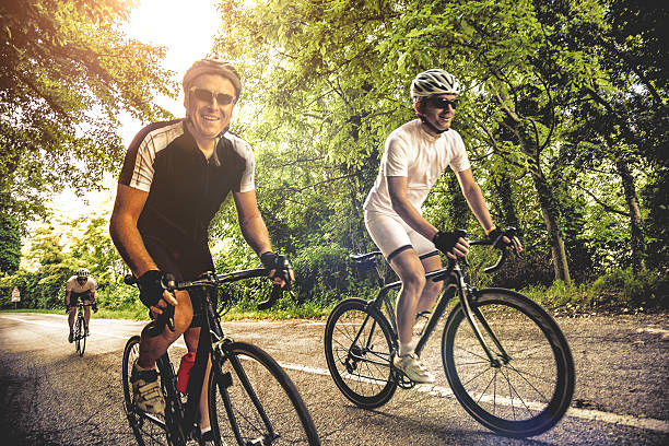 cycling on a country road - friends riding bildbanksfoton och bilder