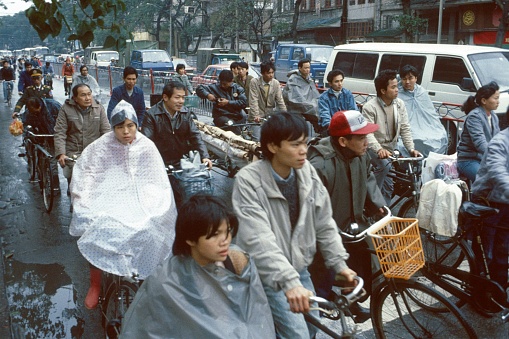 Beijing, China, 1985. Cyclists and motorists at a traffic light in Beijing on a rainy day.