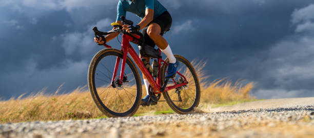 Cyclists practicing on gravel roads in bad weather day stock photo