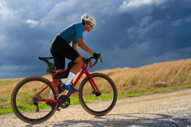 Cyclists practicing on gravel roads  in bad weather day stock photo
