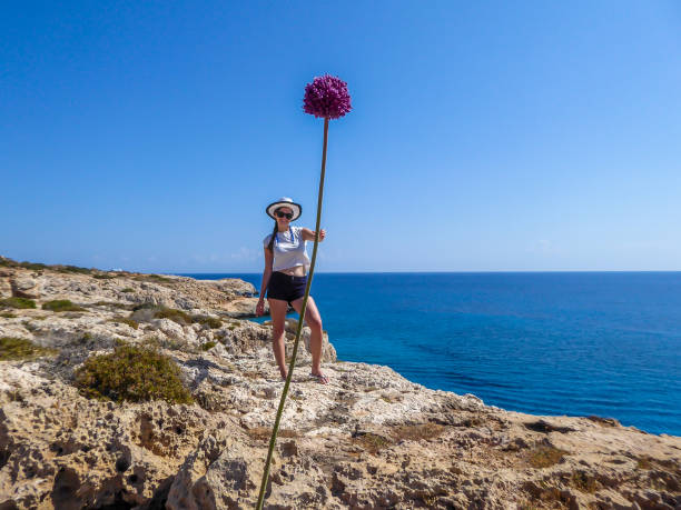 cipro - ragazza che tiene in mano un fiore gigantesco - forced perspective foto e immagini stock