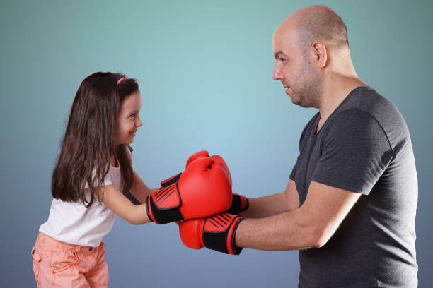 dad and daughter having boxing training stock photo