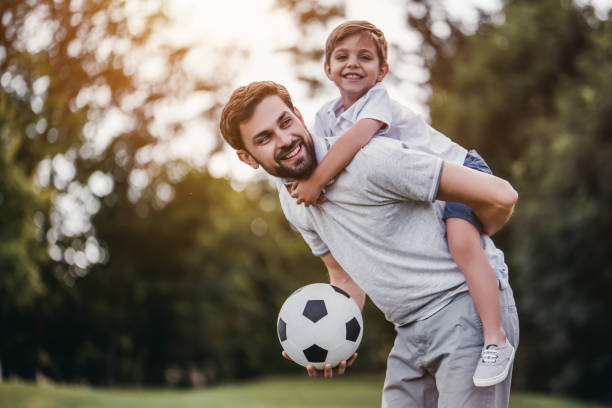 pai com o filho jogando futebol, soccer - son dad workout - fotografias e filmes do acervo