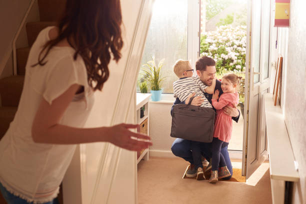 daddy's homecoming hug a young family rush to the front door as daddy comes home from work or a stint away . worker returning home stock pictures, royalty-free photos & images