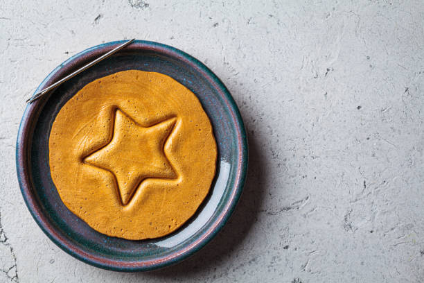 Dalgona Candy - South Korean treat. Round sugar cookie with star inside. stock photo