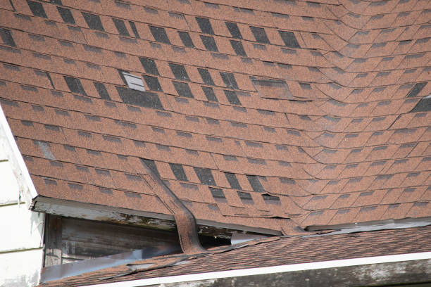 Damaged and old roofing shingles and gutter system on a house stock photo
