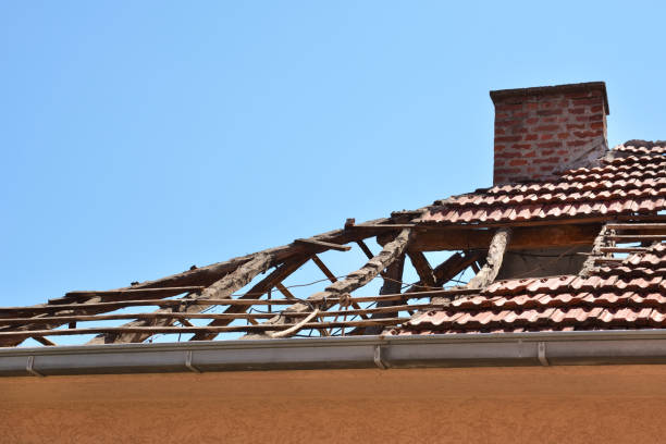 Damaged roof with fallen tiles after storm disaster stock photo