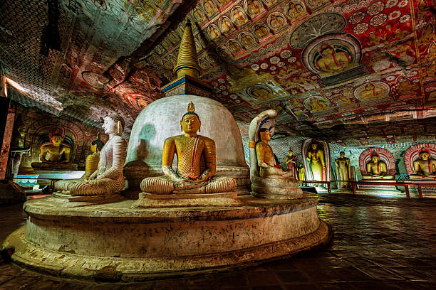 Dambulla cave temple - Buddha statues, Sri Lanka Buddha statue inside Dambulla cave temple, Sri Lanka. Dambulla cave temple also known as the Golden Temple of Dambulla is a World  Heritage Site in Sri Lanka, situated in the central part of the country. This site is situated 148 km east of Colombo and 72 km  north of Kandy. It is the largest and best-preserved cave temple complex in Sri Lanka. This temple complex dates back to the first century BCE. There are more than 80 documented caves in  the surrounding area. Major attractions are spread over 5 caves, which contain statues and paintings. These paintings and statues  are related to Lord Buddha and his life. There are total of 153 Buddha statues, 3 statues of Sri Lankan kings and 4 statues of  gods and goddesses. dambulla stock pictures, royalty-free photos & images