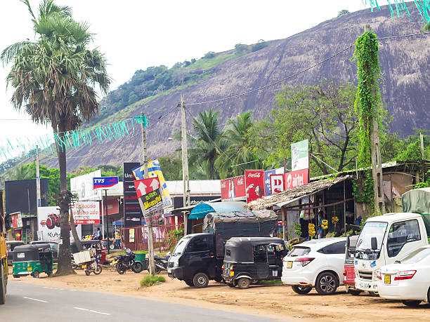 Dambulla market town near royal cave temple in Sri Lanka Detail from small town Dambulla with crowd of cars and commercial panels on stores during a business day. It is across big wholesale fruits and vegetable market and few kilometers from Temple houses in the caves known as Dambulla royal cave Temple or Golden Temple and is one of UNESCO World Heritage sites in Sri Lanka. There are around 153 statues of Buddha representing everyday life, some statues of kings and Hindu gods. dambulla stock pictures, royalty-free photos & images