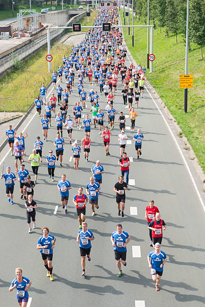 Damloop 2015 Amsterdam, the Netherlands - September 20, 2015: Color image of people running the Damloop 2015 version. Damloop is a traditional running event held between Amsterdam and Zaandam in the Netherlands. 10 miles version is the most popular one attracting tens of thousand of people every year. amsterdam noord stock pictures, royalty-free photos & images