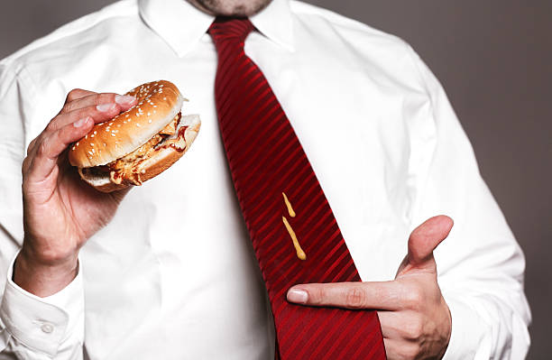 Damn! angry businessman with shirt, tie and burger. mustard spots on tie. Need more pictures like this: ketchup smear stock pictures, royalty-free photos & images