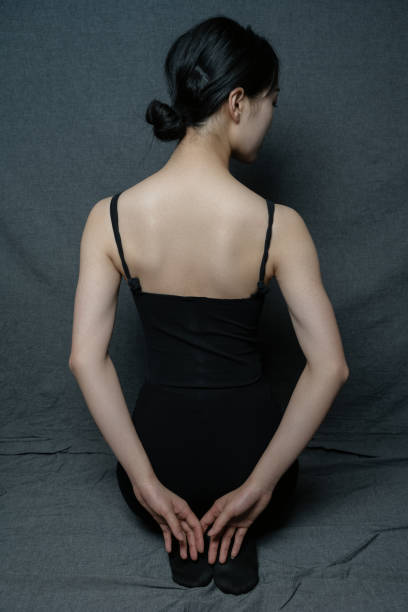 A dancer dressed in black practices her dance moves stock photo