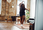 Happy woman with excess weight smiling and dancing alone in sports clothes