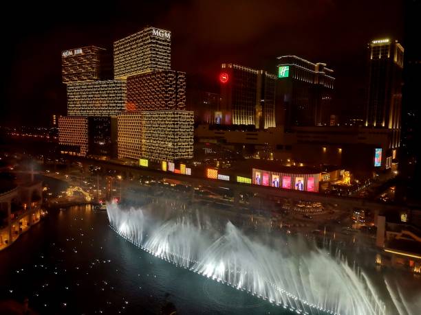 Dancing fountains at Wynn Palace by night, Cotai strip, Macau High angle view by night from Wynn Palace, the second luxury integrated resort in the Macau Special Administrative Region following the launch of Wynn Macau. It"s located in the Cotai Strip area and features a 28-story hotel with 1,706 rooms, suites and villas, meeting facilities, and approximately 420,000 square feet of casino space. The resort also features a 8-acre Performance Lake with a choreographed display of water, music and light and the unique SkyCab cable car. cotai strip stock pictures, royalty-free photos & images