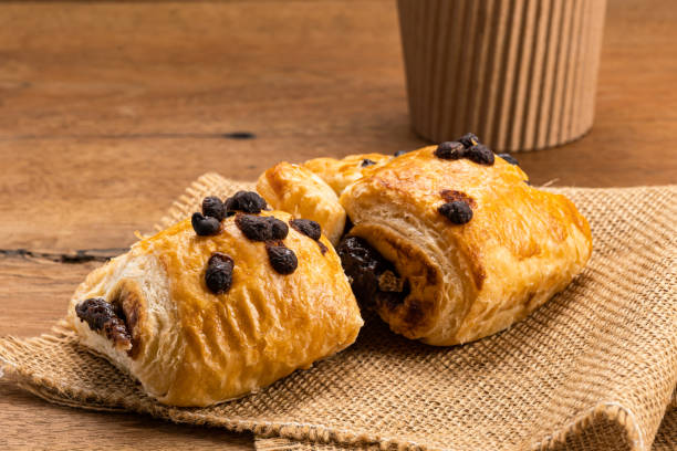 Danish Pastry filled with sweet chocolate cream topping with chocolate chips on sack cloth. stock photo