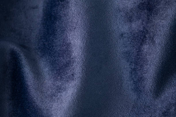 Dark blue color velvet fabric background. Close up of blue textured background stock photo