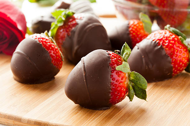 Dark chocolate covered strawberries lying on a cutting board Gourmet Chocolate Covered Strawberries for Valentine's Day strawberries stock pictures, royalty-free photos & images