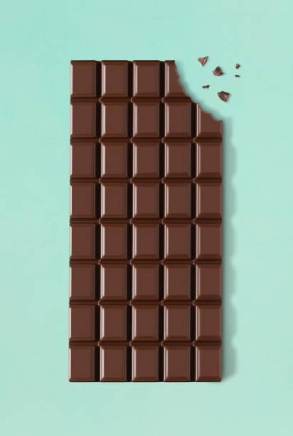 Dark chocolate with missing bite Chocolate bar with a missing bite on white background eaten stock pictures, royalty-free photos & images