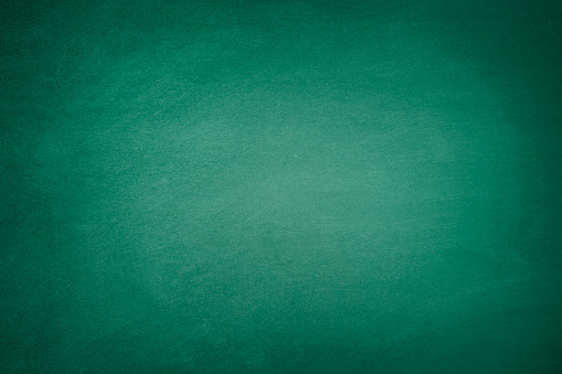 Blank green chalkboard background with traces of erased chalk