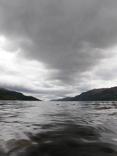 Dark Lake Taken on Lock Ness near Fort Augustus with the sky and the land converging in the distant  normalisaverage stock pictures, royalty-free photos & images