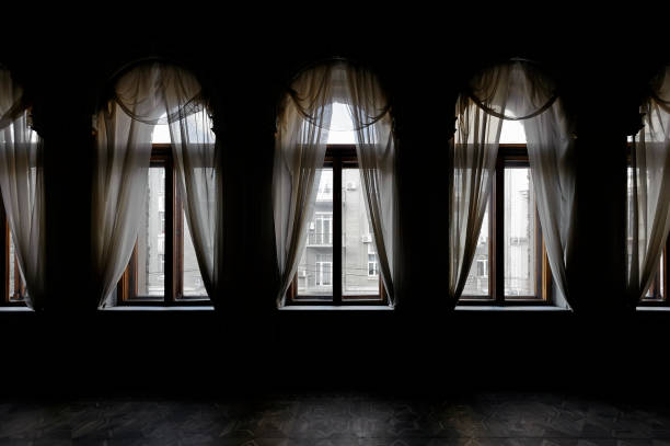 Dark room with curtain before old windows stock photo