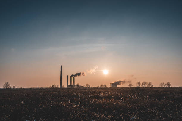 Dark silhouette of the power plant against the setting sun stock photo