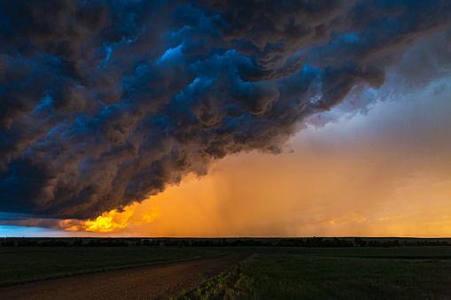Dark, turbulent, stormy sky with rain curtain at sunset in South Dakota