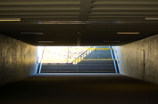 Dark underpass with staircase at the end.