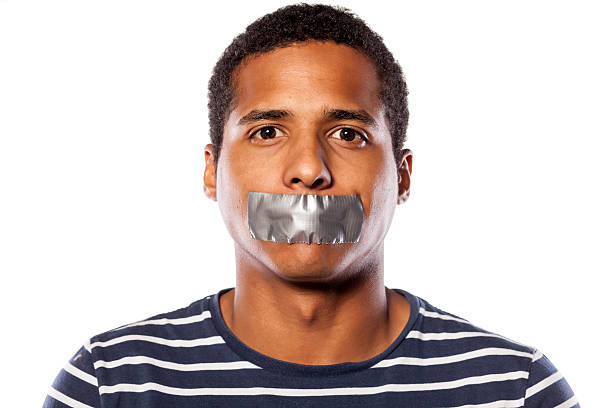 dark-skinned young man with adhesive tape over his mouth - plakband mond stockfoto's en -beelden