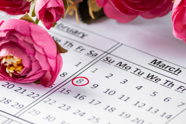 Date on the calendar for Women's Day and flowers. stock photo