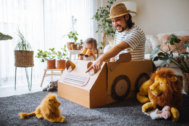 Daughter and father are on safari at home with a handmade cartoncar stock photo