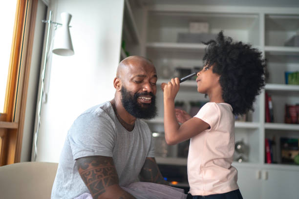 Daughter doing makeup to shy father at home Daughter doing makeup to shy father at home shy photos stock pictures, royalty-free photos & images