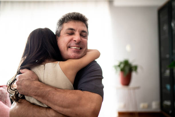 Daughter embracing father at home Daughter embracing father at home fathers day stock pictures, royalty-free photos & images