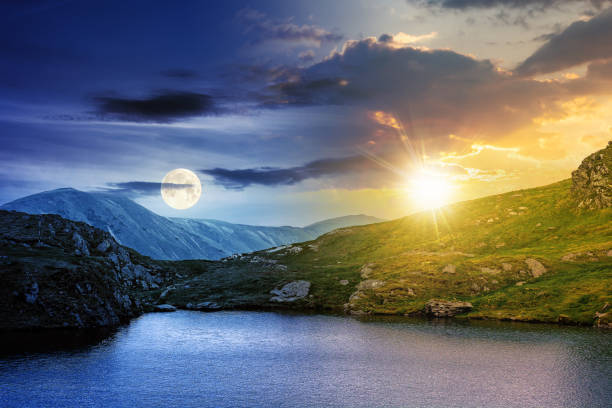 day and night change above the landscape with lake stock photo