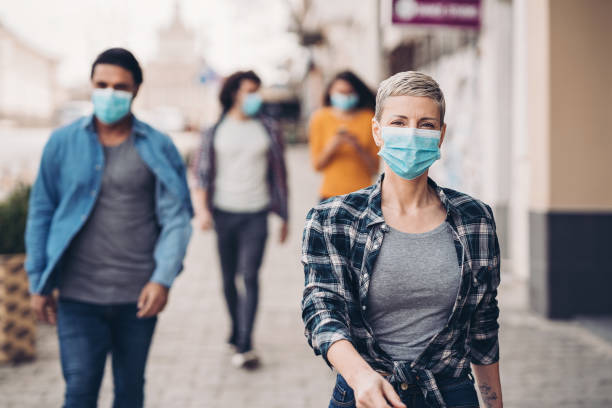 A day in the city during flu epidemic Group of people with protective masks outdoors in the city severe acute respiratory syndrome photos stock pictures, royalty-free photos & images