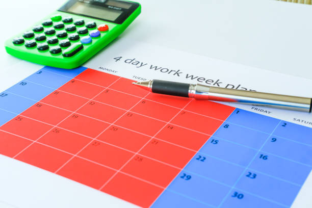 4 day work week calendar with pen and calculator stock photo