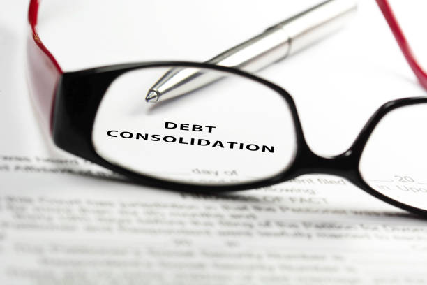 Debt consolidation loan concept through reading glasses. Debt consolidation loan concept through reading glasses. Debt Consolidation stock pictures, royalty-free photos & images