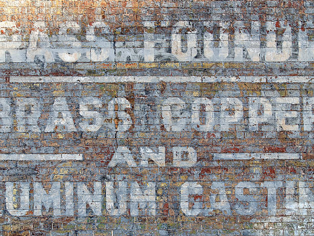 Decaying sign on an old brick wall. stock photo