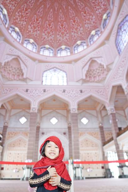 A decent looking girl wandering alone inside of a mosque. stock photo