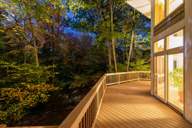 Deck on Home in Woods at Night Large composite deck on a luxury home in the woods photographed at night.  Concepts could include architecture, design, outdoor living, luxury living, nature, others. deck stock pictures, royalty-free photos & images
