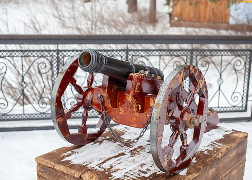 The decorative cannon is reminiscent of the old wars. A cannon with round wheels is installed as a decoration in the park.