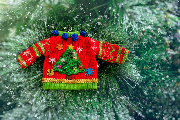 Decorative Christmas holiday knit sweater ornament hanging on a tree, greeting card with copy space. stock photo