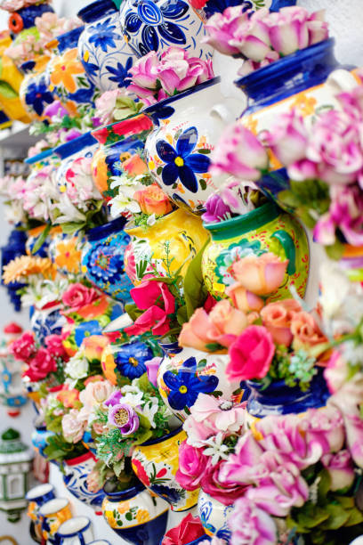 Decorative handmade flowerpots with artificial flowers Vertical full frame image close up view background hanging on wall decorative handmade flowerpots with artificial flowers, Mijas village traditional souvenir gift, Costa Del Sol, Andalusia, Spain malaga stock pictures, royalty-free photos & images